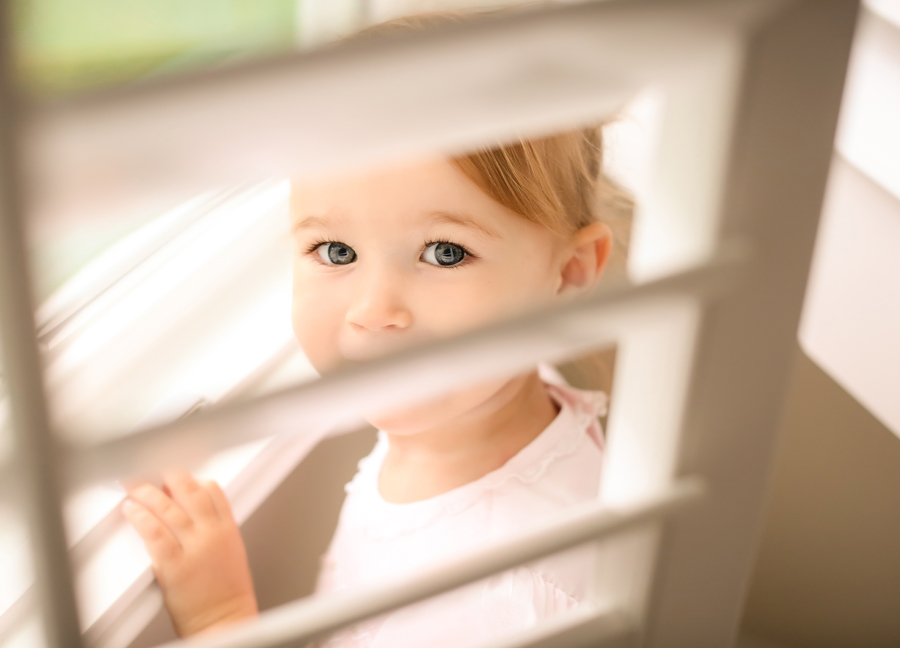 Image of a child by the window at an in-home newborn session in Chandler, Arizona