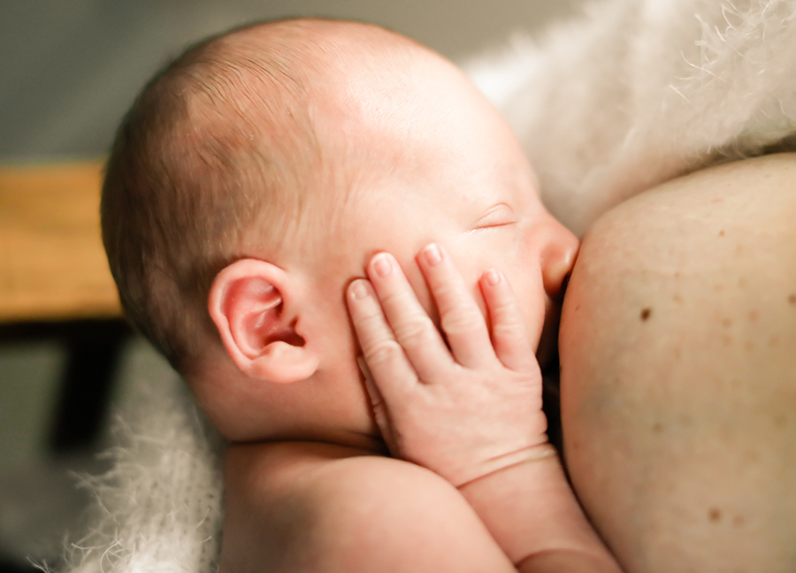 Closeup image of a baby nursing at an in-home newborn session in Chandler, Arizona