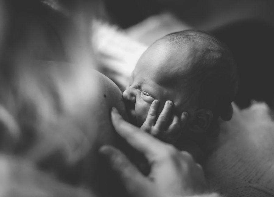 Image of a mother breastfeeding her baby at an in-home newborn session in Chandler, Arizona