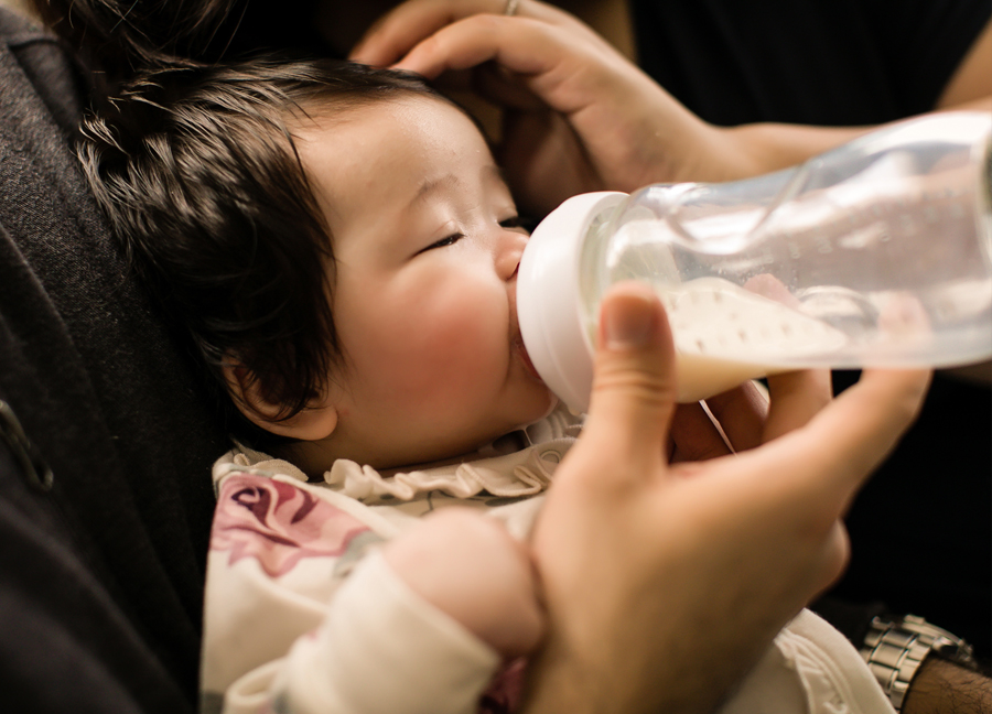 Parents bottle-feeding their child.