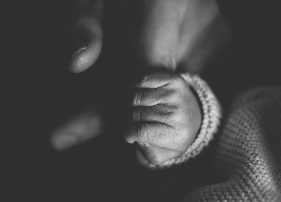 Detail of baby holding his father's finger.