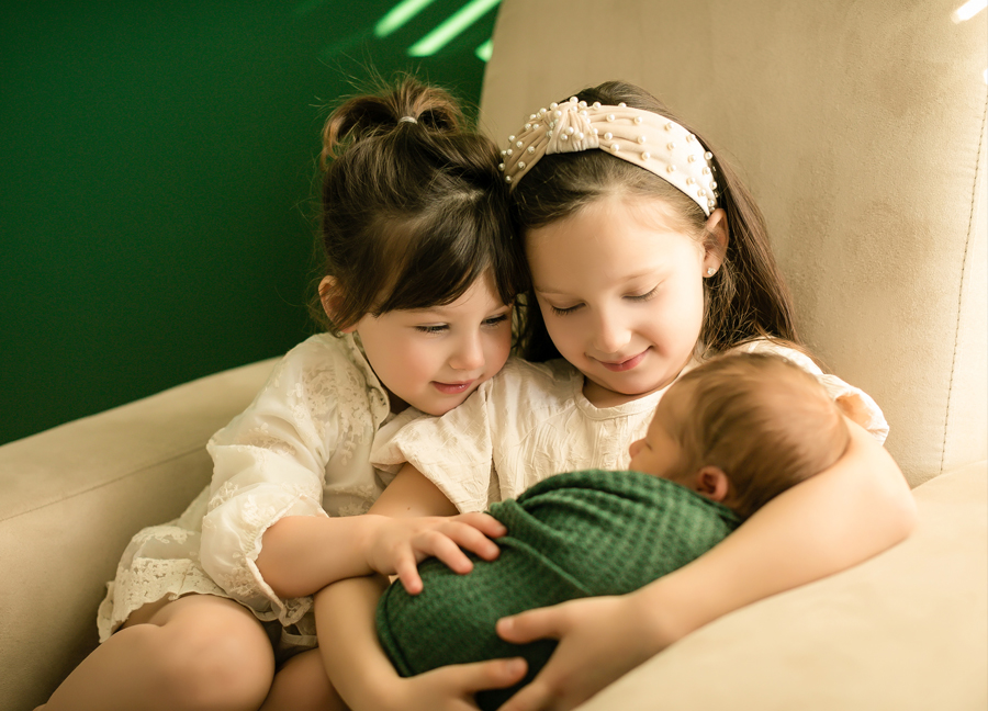 Image of siblings holding their baby brother at a newborn session in Scottsdale, Arizona
