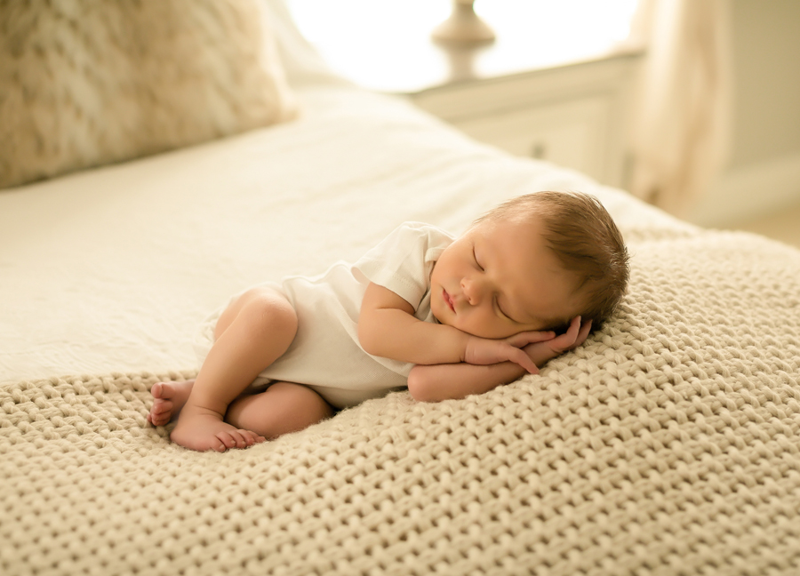 Image of a posed baby on the bed at an in-home newborn session in Scottsdale, Arizona