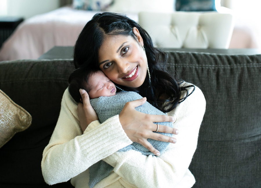 A mother holding her swaddled newborn baby at an in home newborn session in Northern Virginia.