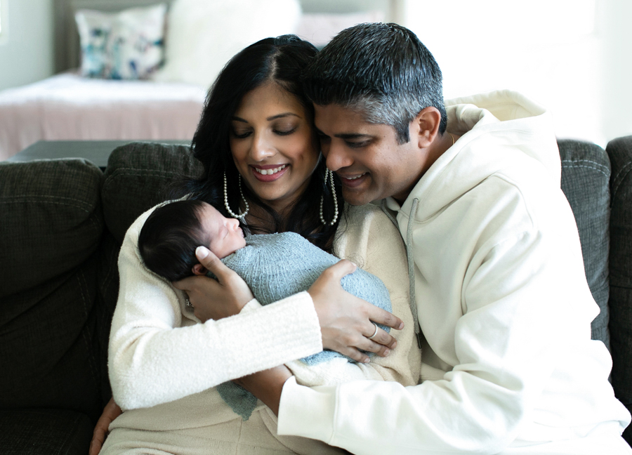 A couple holding their swaddled newborn baby at an in home newborn session in Northern Virginia.