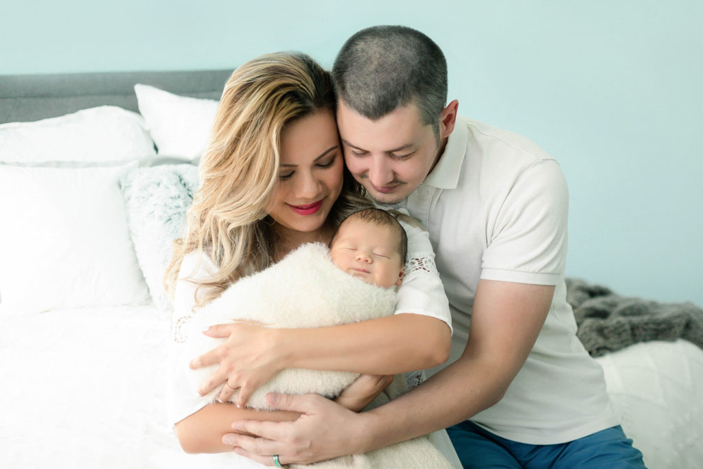 A couple holding their swaddled baby during a Northern Virginia newborn photography session with Stephanie Honikel Photography.