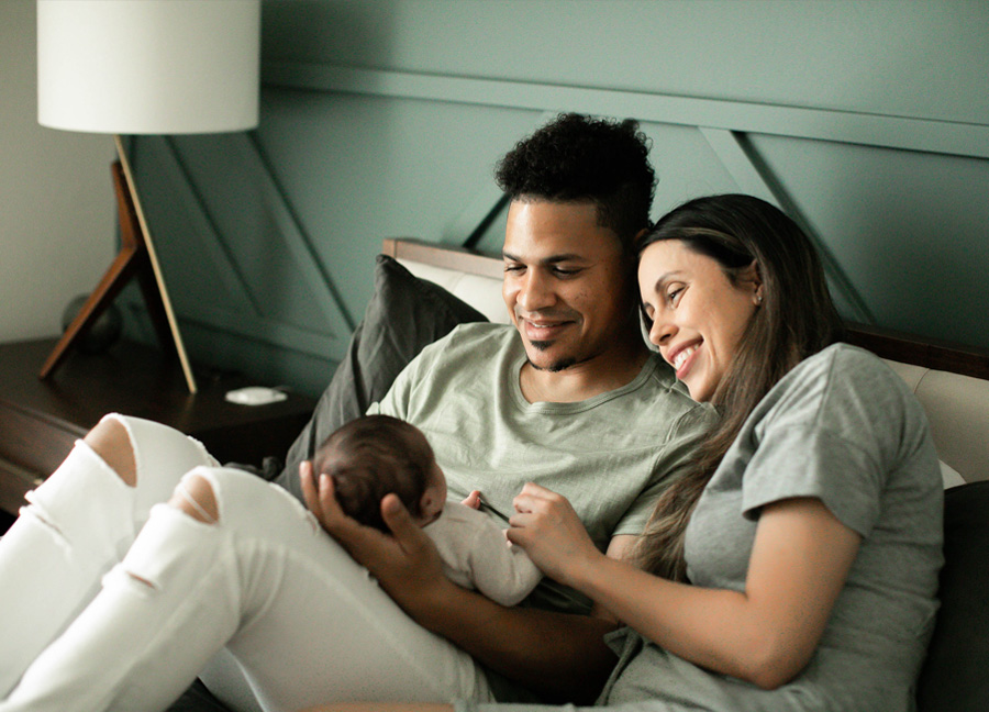 A couple holding their newborn baby during a In Home Newborn Photography Sessionwith Stephanie Honikel Photography.