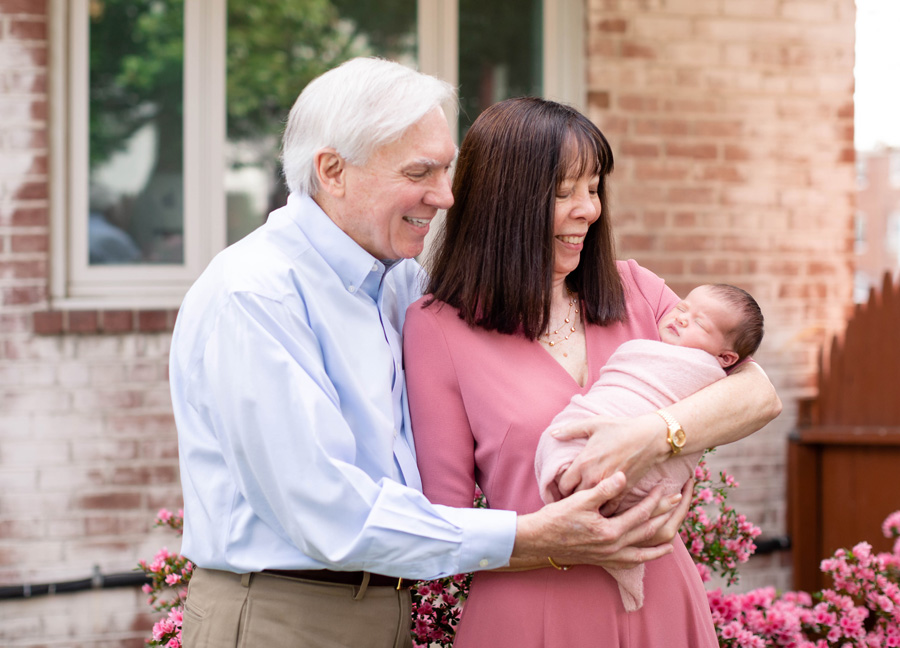 Grandparents holding their newborn granddaughter during their Northern Virginia Newborn Photography session in Arlington.