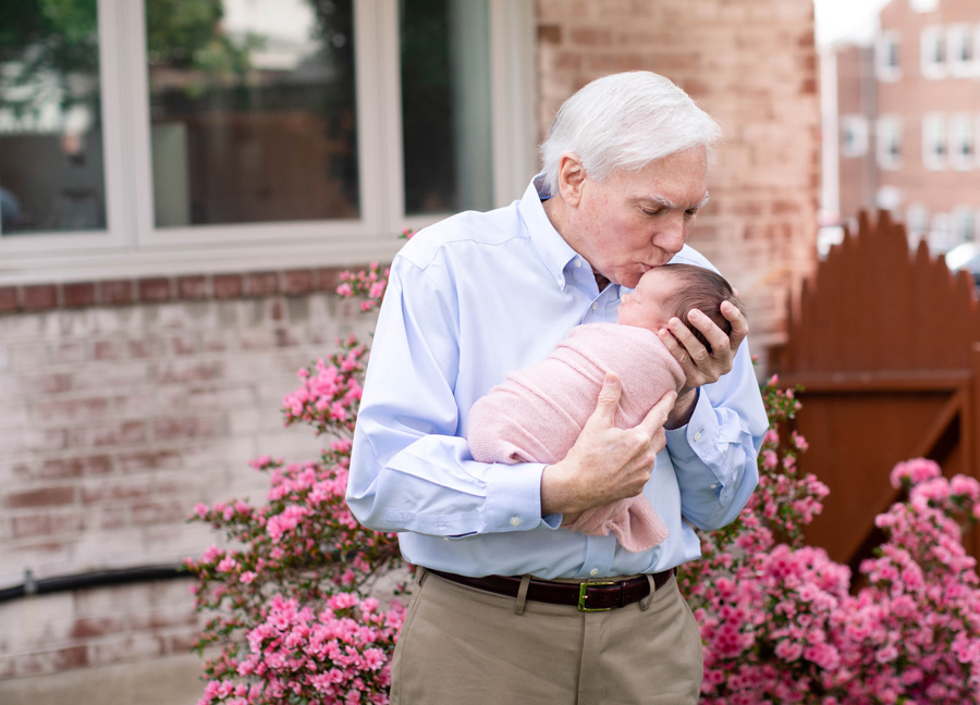 A grandfather kissing his baby granddaughter captured by Northern Virginia newborn photographer Stephanie Honikel.