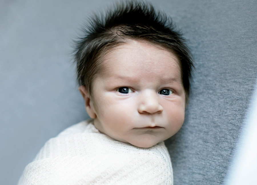 A baby boy with a head full of hair captured by Ashburn Virginia newborn photographer. 