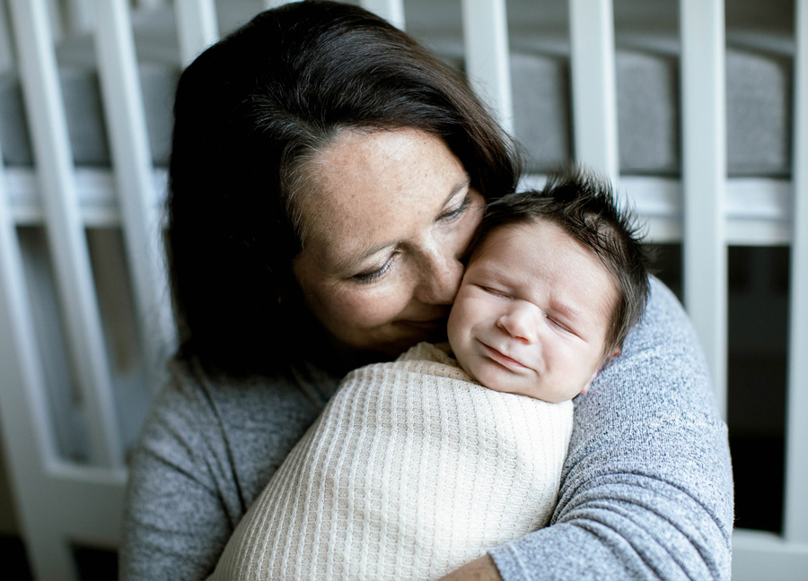 A mother loving on her swaddled baby boy during their Ashburn Virginia newborn photography session.