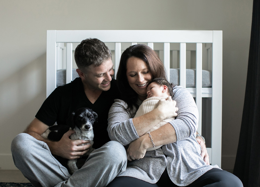 A family photo in front of a crib captured by Ashburn Virginia Newborn Photographer, Stephanie Honikel.