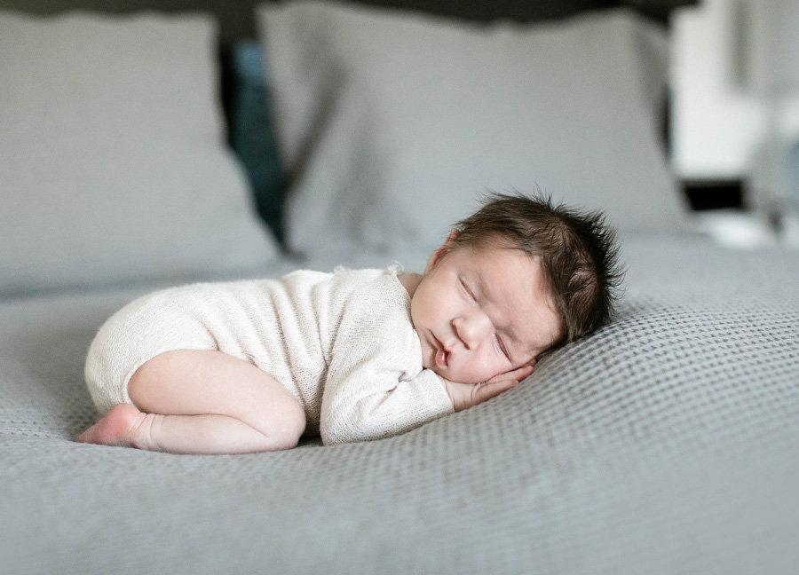 Posed baby boy on a bed captured by Ashburn Virginia newborn photographer, Stephanie Honikel.
