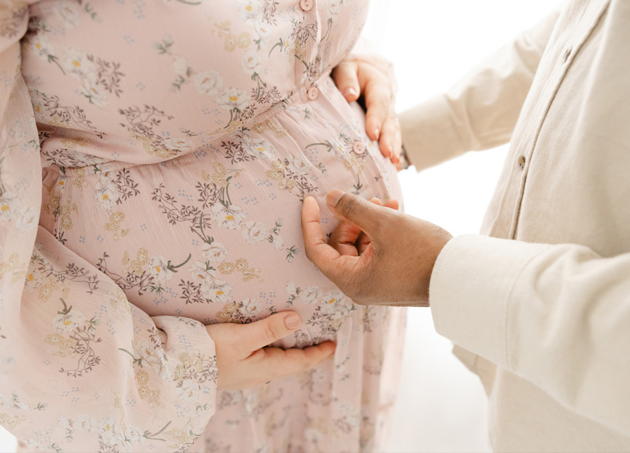 A father to be gently stroking over his wife's baby belly 