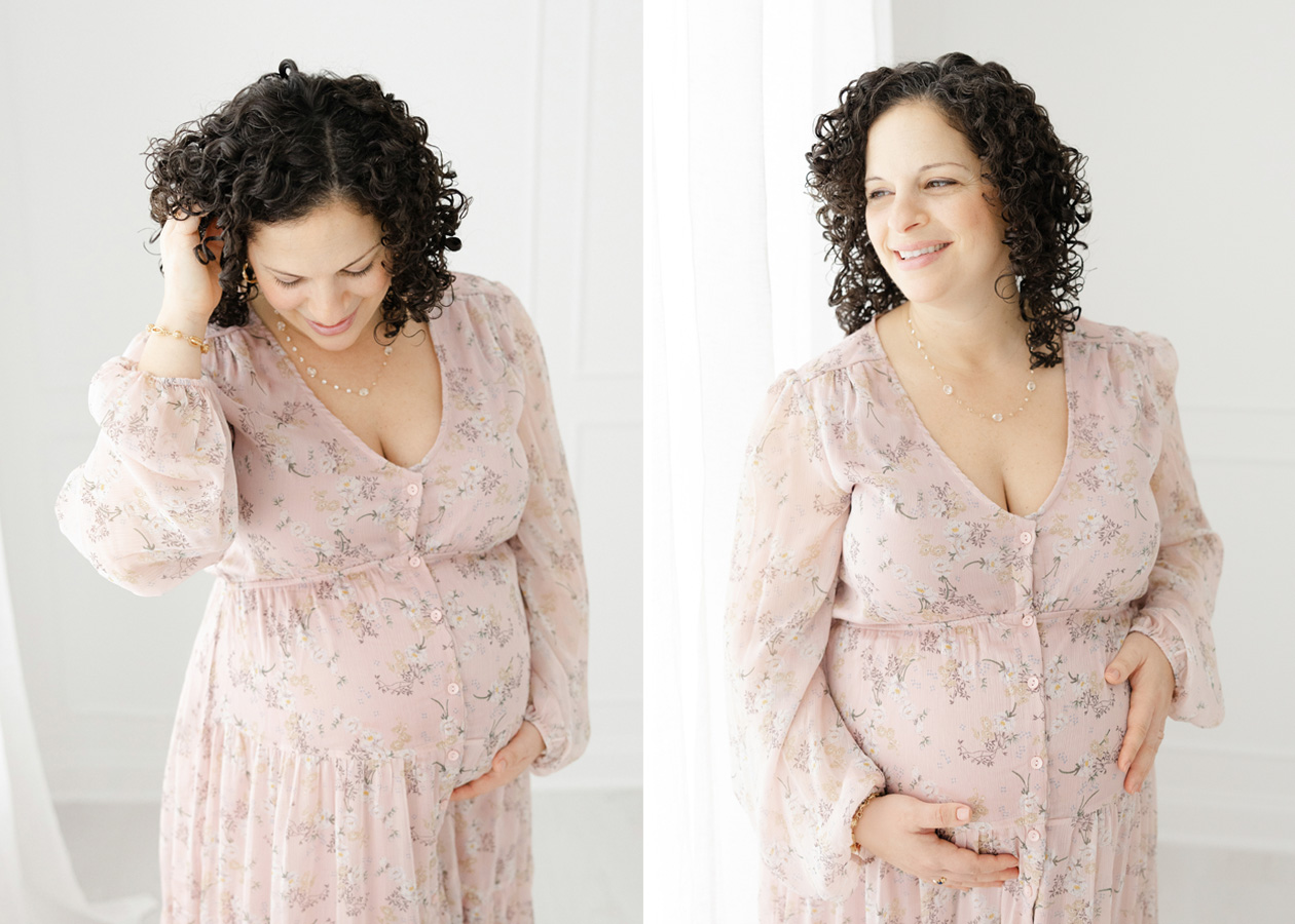 A mother to me in a pink blush floral dress gently touching her baby belly