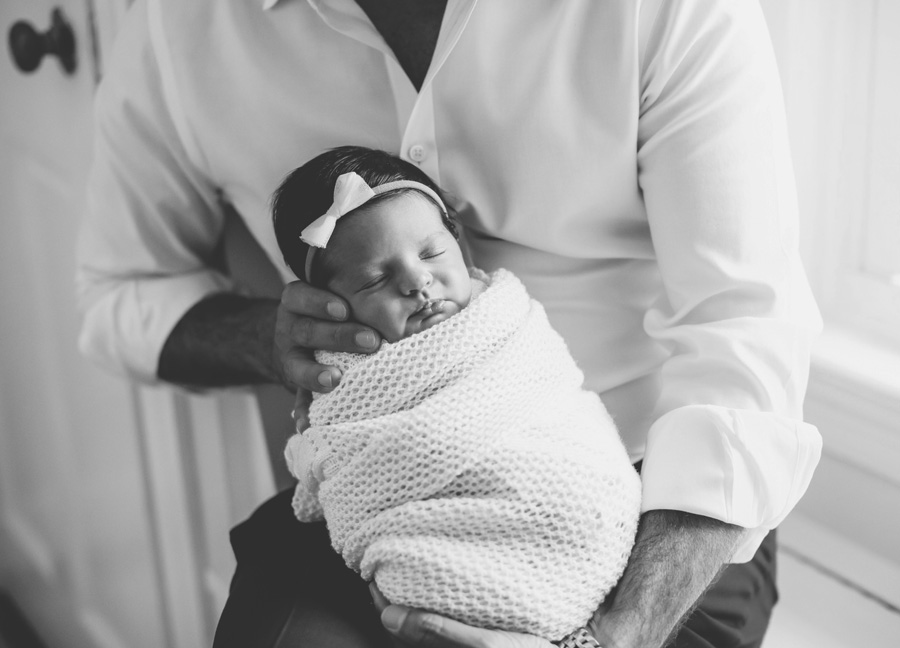 black and white photo of a dad and newborn baby