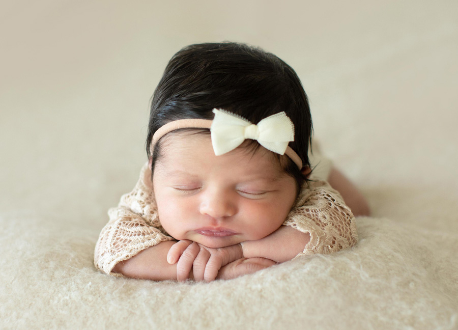 Washington D.C. newborn photographer captures a baby resting on her arms