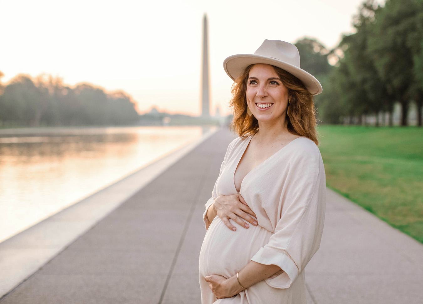 best prenatal massage in Northern Virginia series featuring pregnant woman wearing a hat and a light dress at the National Mall in D.C.