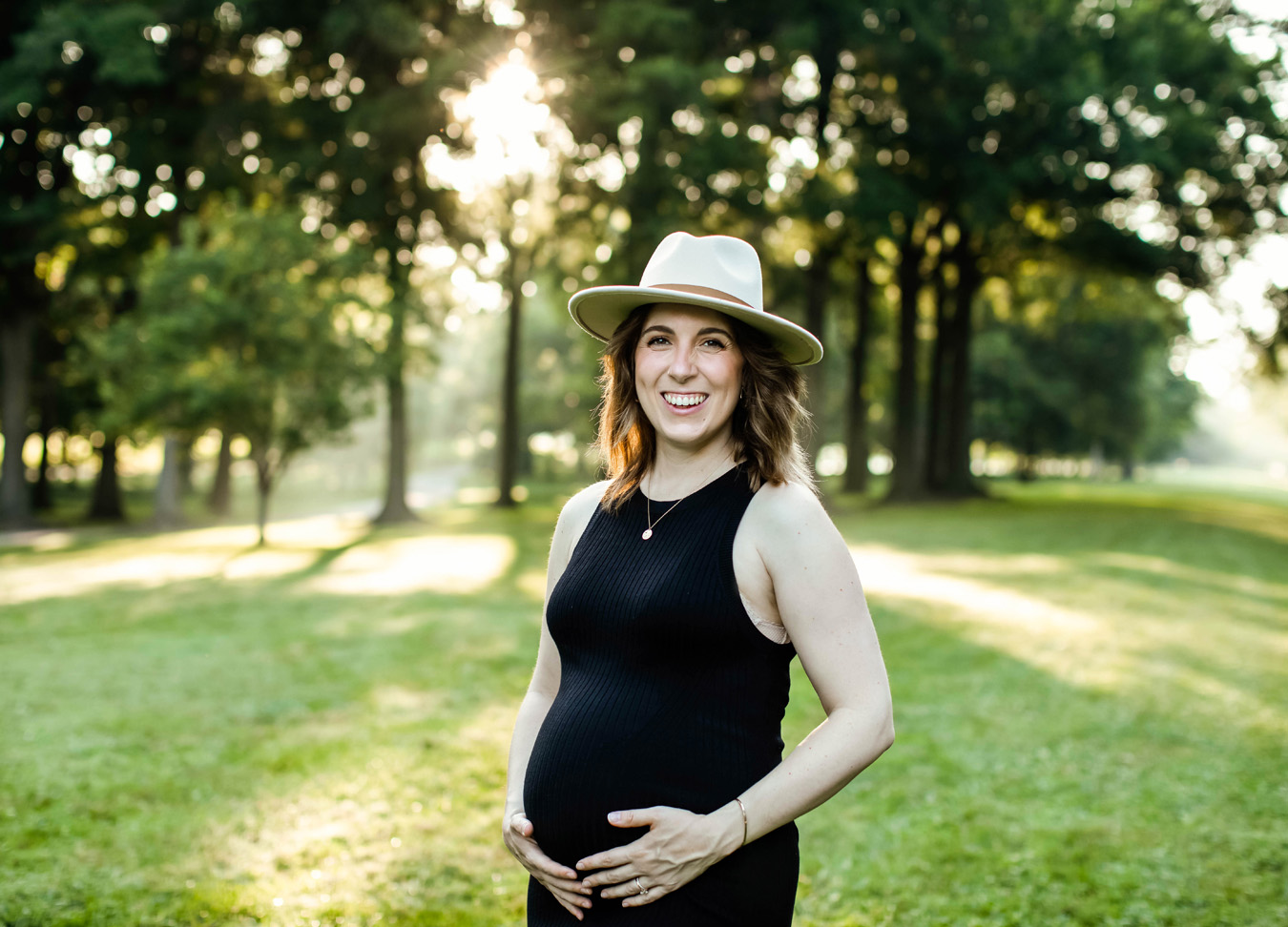 best prenatal massage in Northern Virginia series featuring a pregant mom smiling in a park