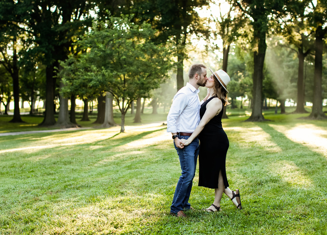 best prenatal massage in Northern Virginia series featuring a couple kissing in the park during their maternity session.