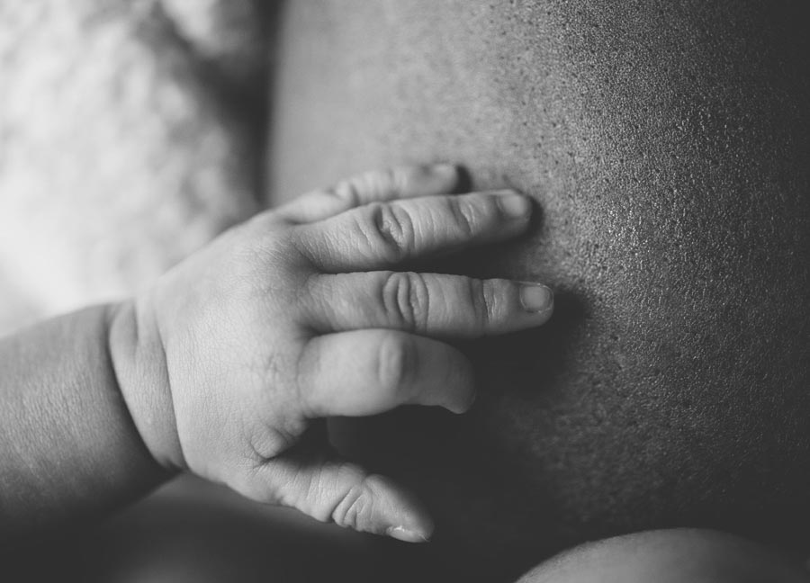 baby hand in black and white touching her mom's skin