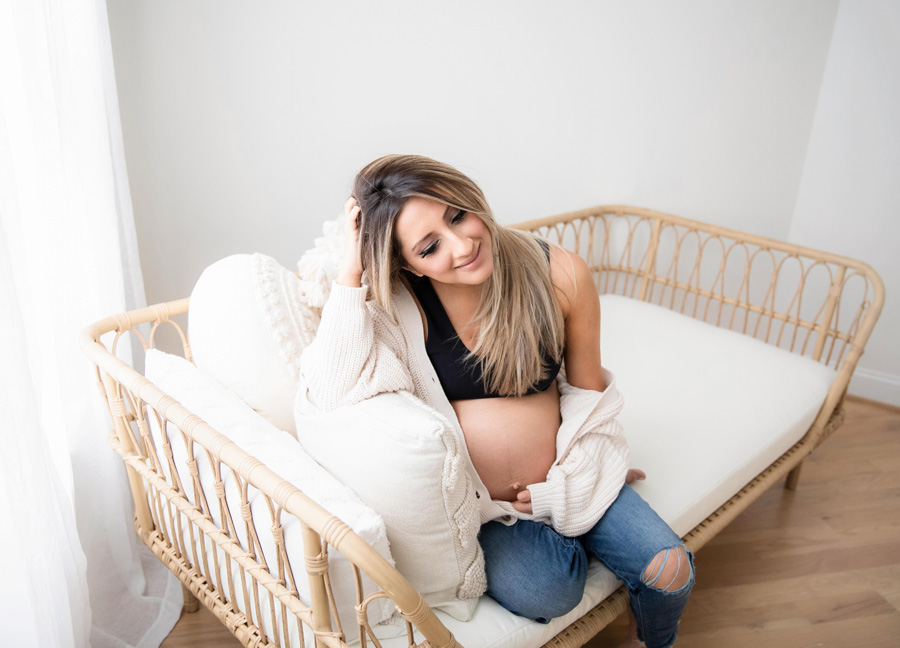 A pregnant woman sitting casually on a sofa - c-section care tips