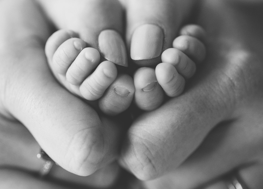 tiny toes held in moms hands