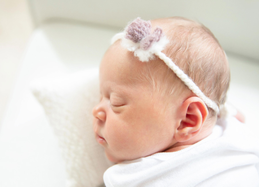 What props should I bring for a newborn photography session?featuring a baby girl with a headband