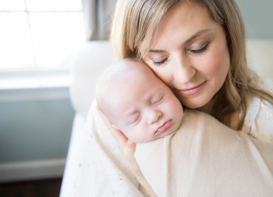 cozy D.C. Christmas newborn session at home featuring a cuddling mom and baby