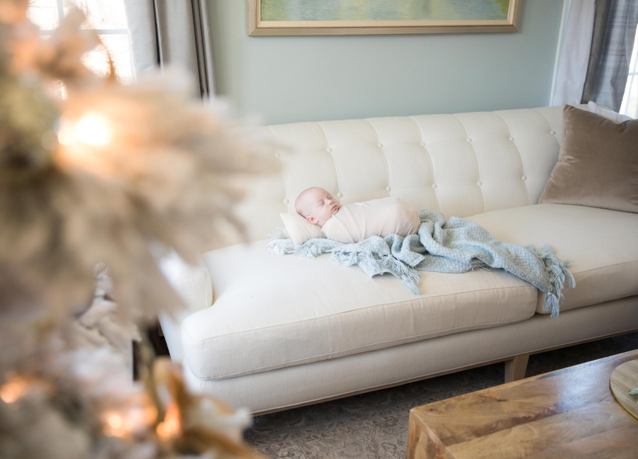 cozy D.C. Christmas newborn session at home featuring a baby swaddled on the couch