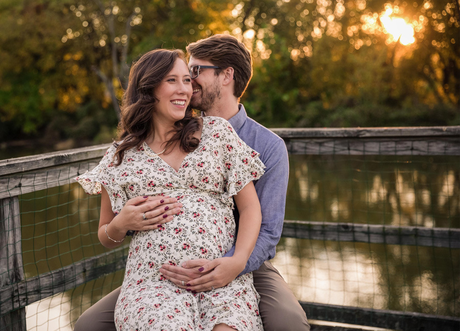 A couple embracing the baby belly at Kingman Island during their maternity photo shoot at sunset.