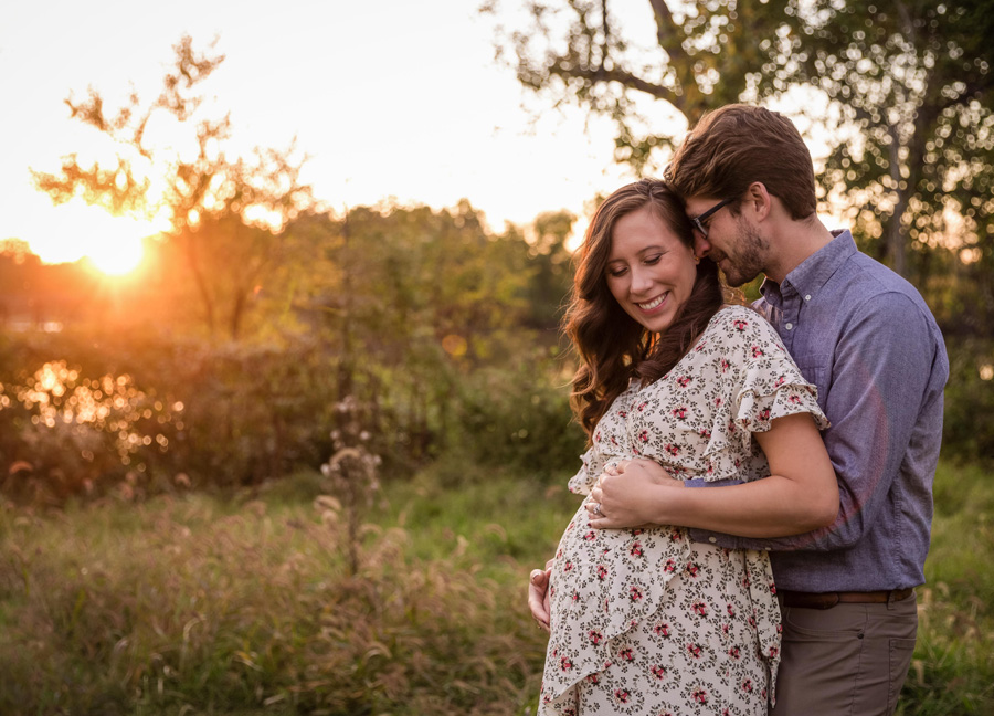Maternity Photo Session In D.C. featuring a man and his wife smiling in a field