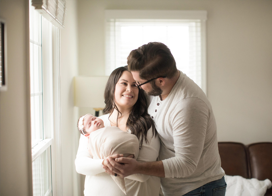 newborn photos with parents - family cuddled together