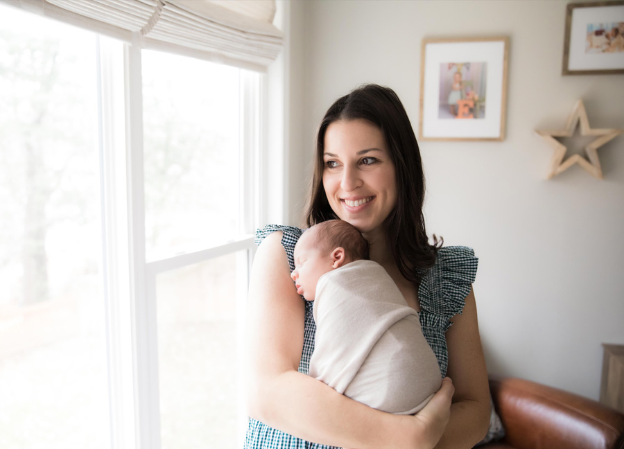 Mom smiling while holding her newborn baby