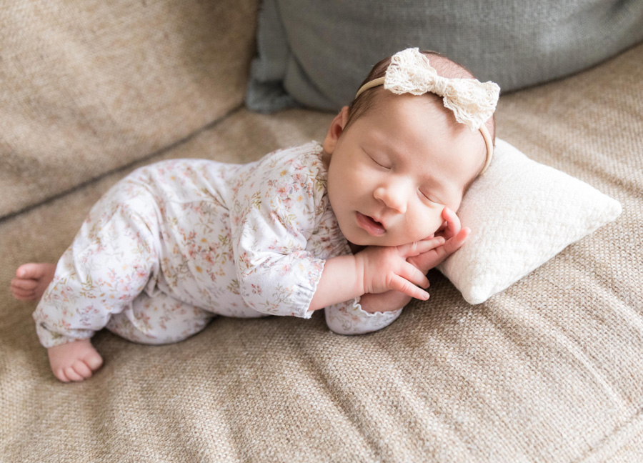 newborn photography with siblings featuring a newborn baby girl laying on her side