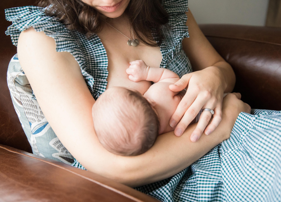 newborn photography with siblings - featuring a mom breastfeeding her newborn