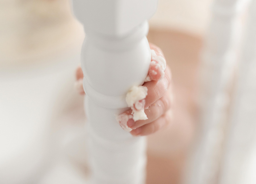 Image of baby fingers holding on to a highchair during a cake smash session in Northern Virginia. 