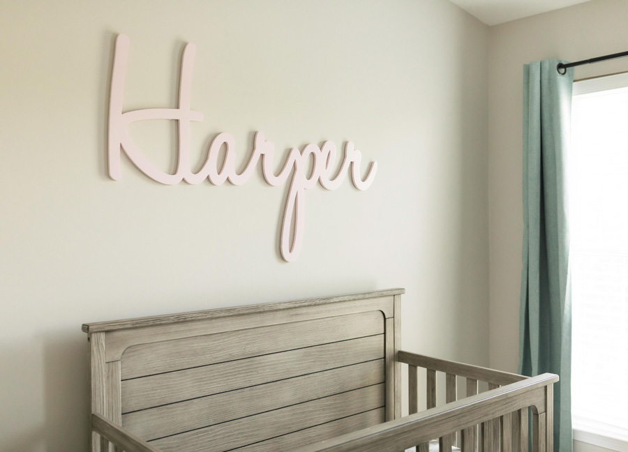 financially prepare for a baby with a nursery set up. Picture shows a crib with the name Harper above it.