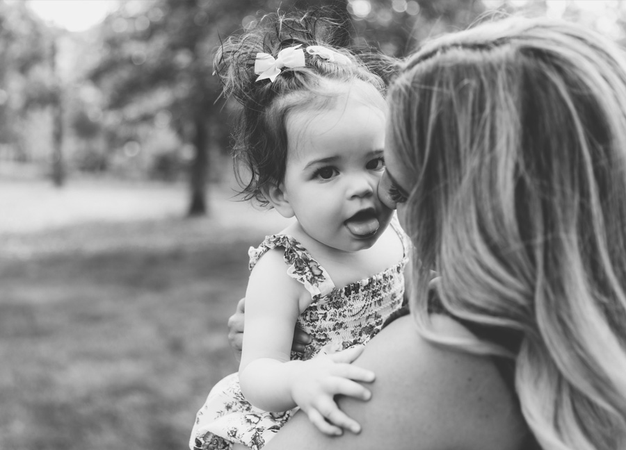 black and white photo of a baby and a mother at an outdoor park