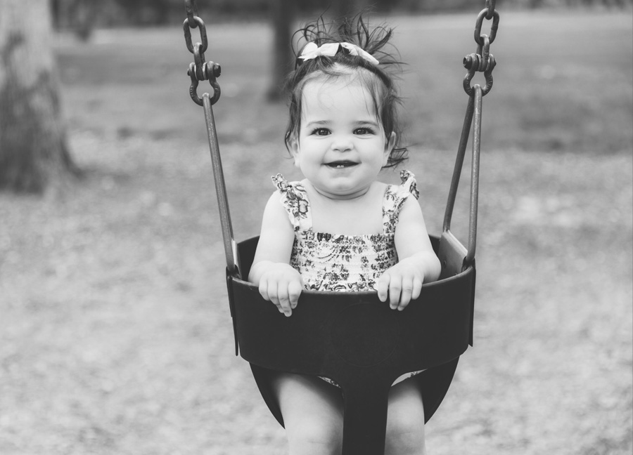northern virginia newborn photographer captiures a black and wite photo of a little girl on a swing