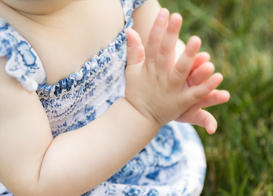 photograph of a baby clapping her hands together