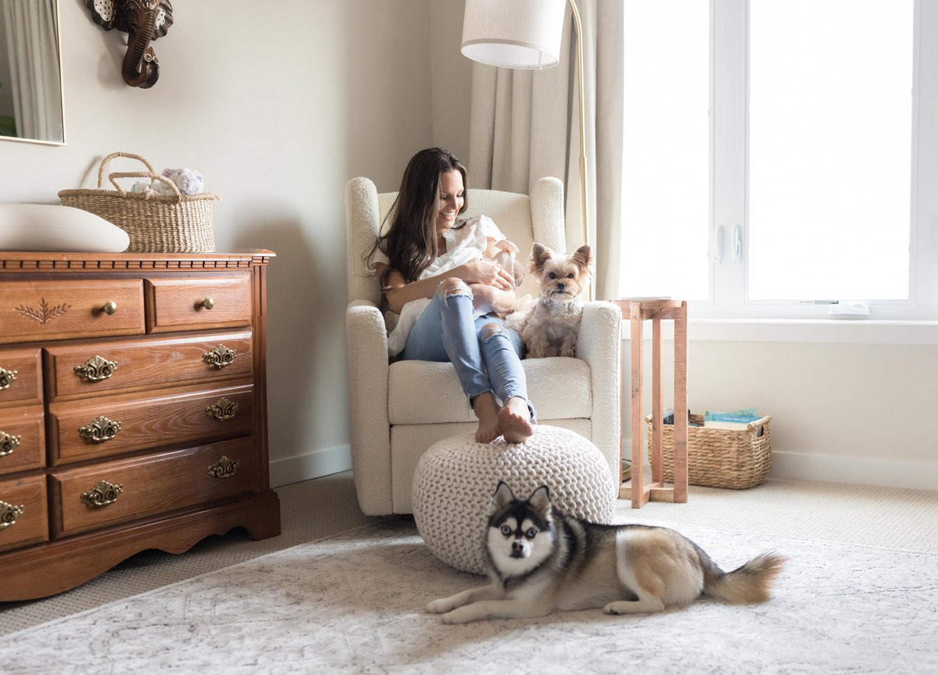DC family photographer, a mother nursing in a white rocking chair with her 2 dogs sitting right beside her
