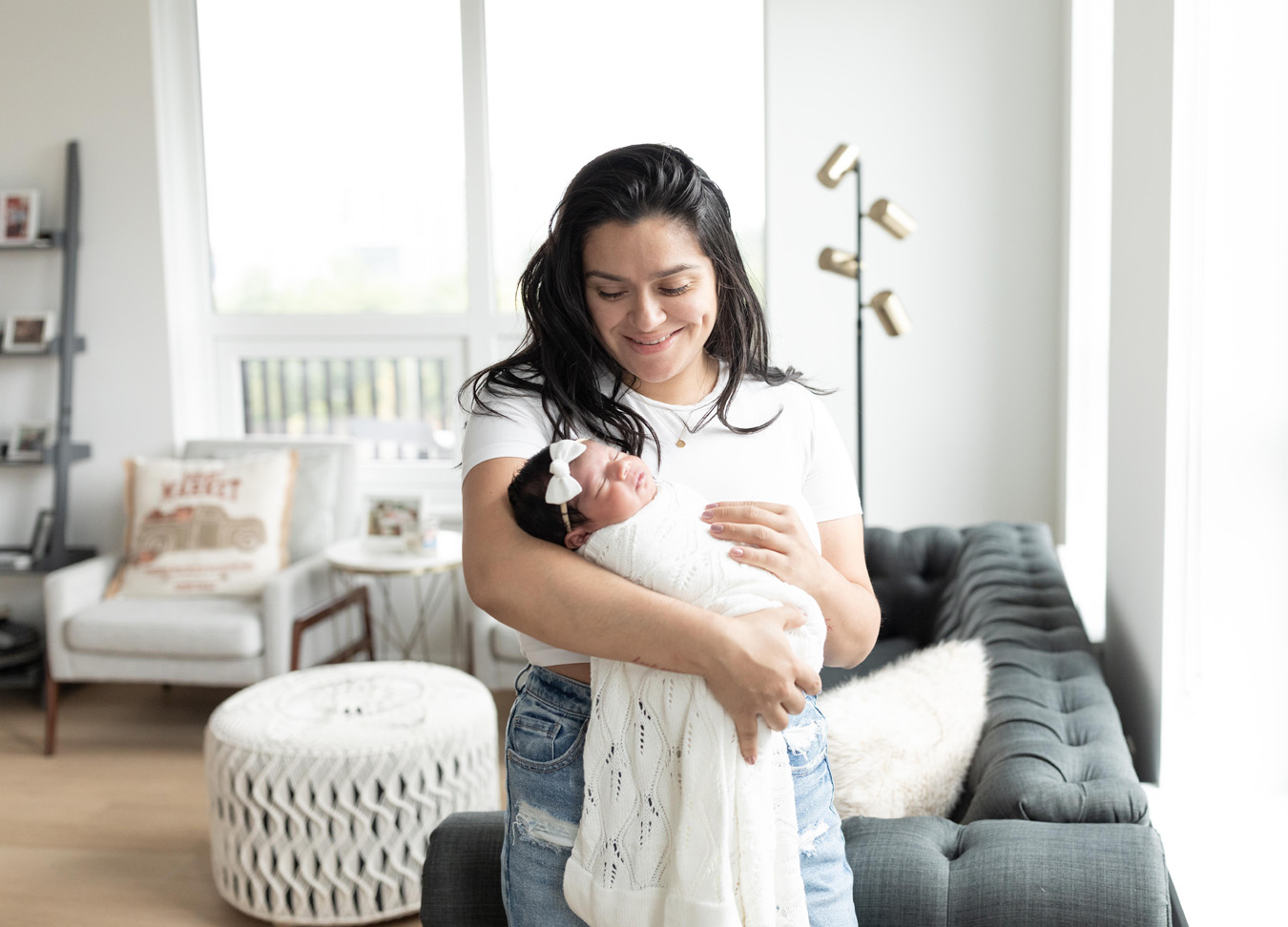 Mom holding newborn baby a in living rooom photographed by a newborn photographer in D.C.