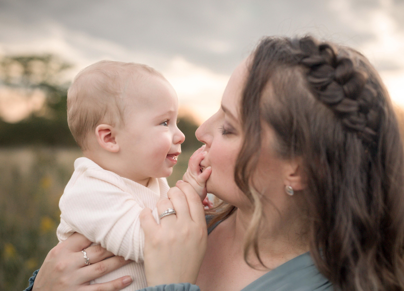 A mother kissing the hand of her baby boy during a Rust Manor family session