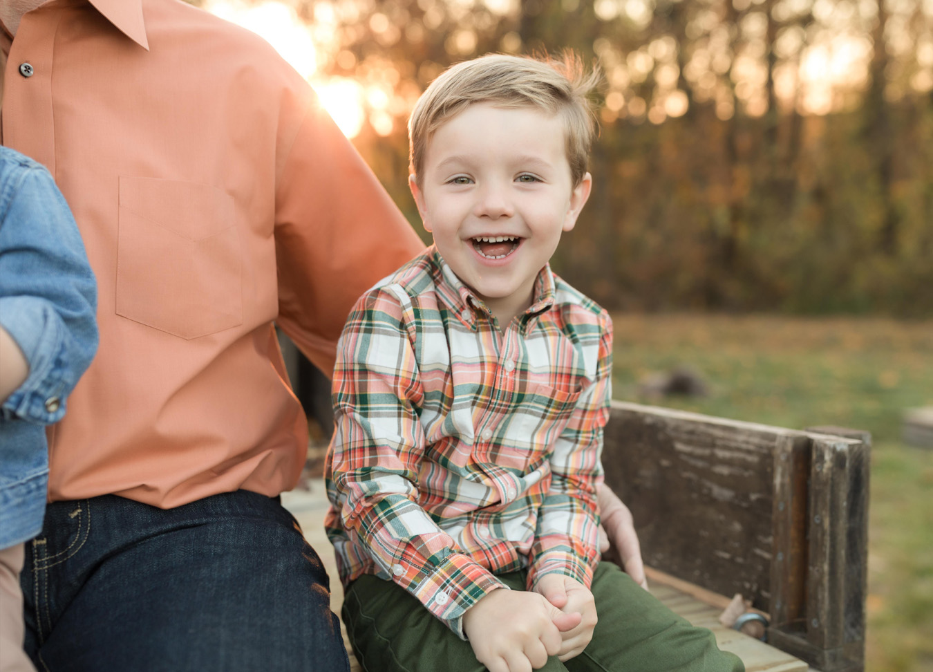 a little boy smiling next to his grandpa, captured by a northern virginia family photographer