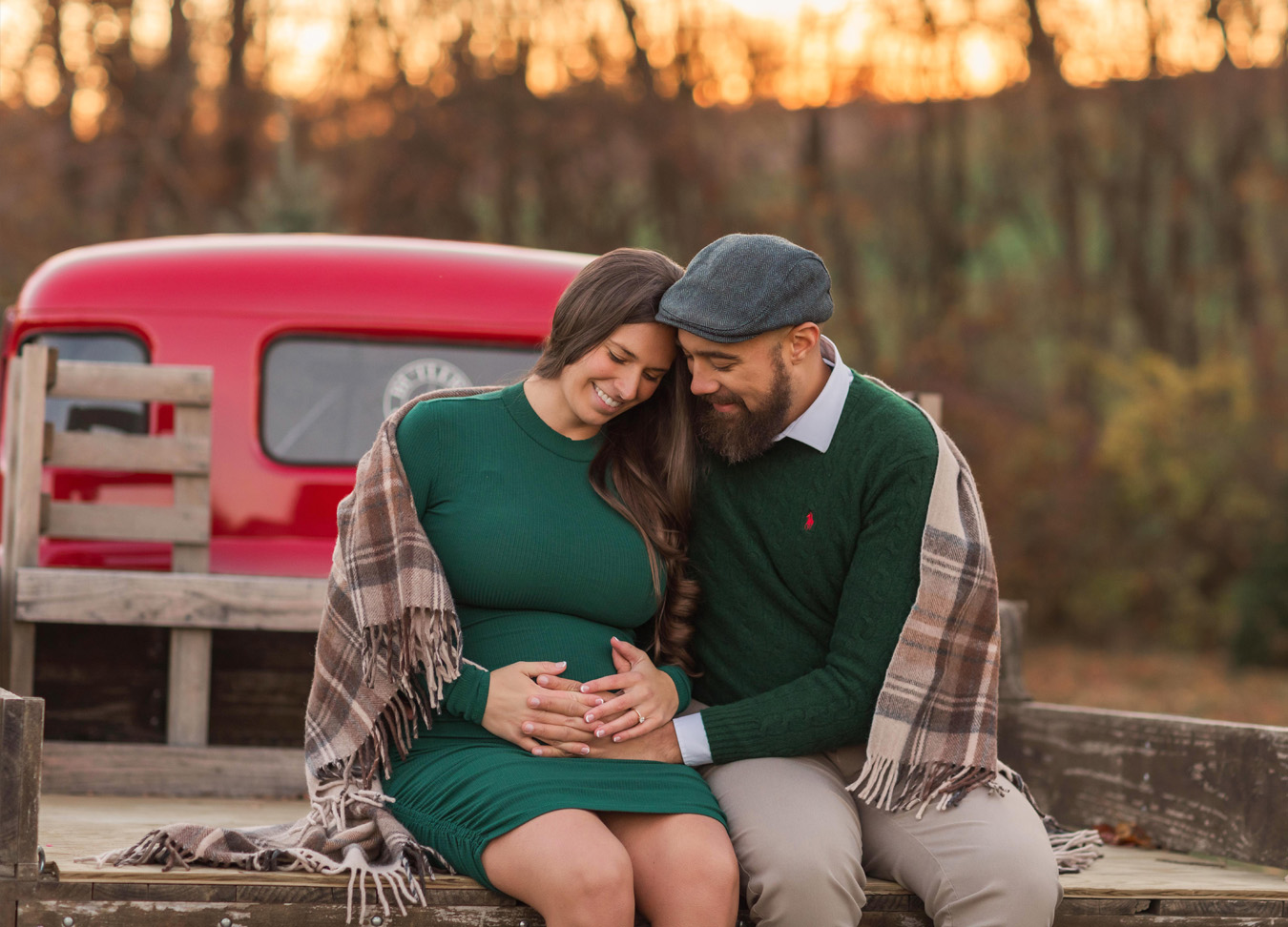 Christmas Maternity Photoshoot in Northern Virginia featuring a pregnant woman and her husband sitting on the bed of a truck.