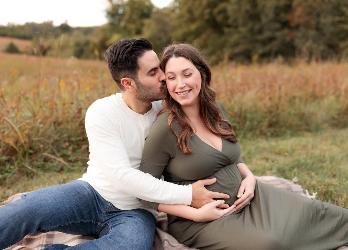 maternity session featuring a pregnant mom and a dad kissing her cheek captured by an expert northern virginia maternity photographer