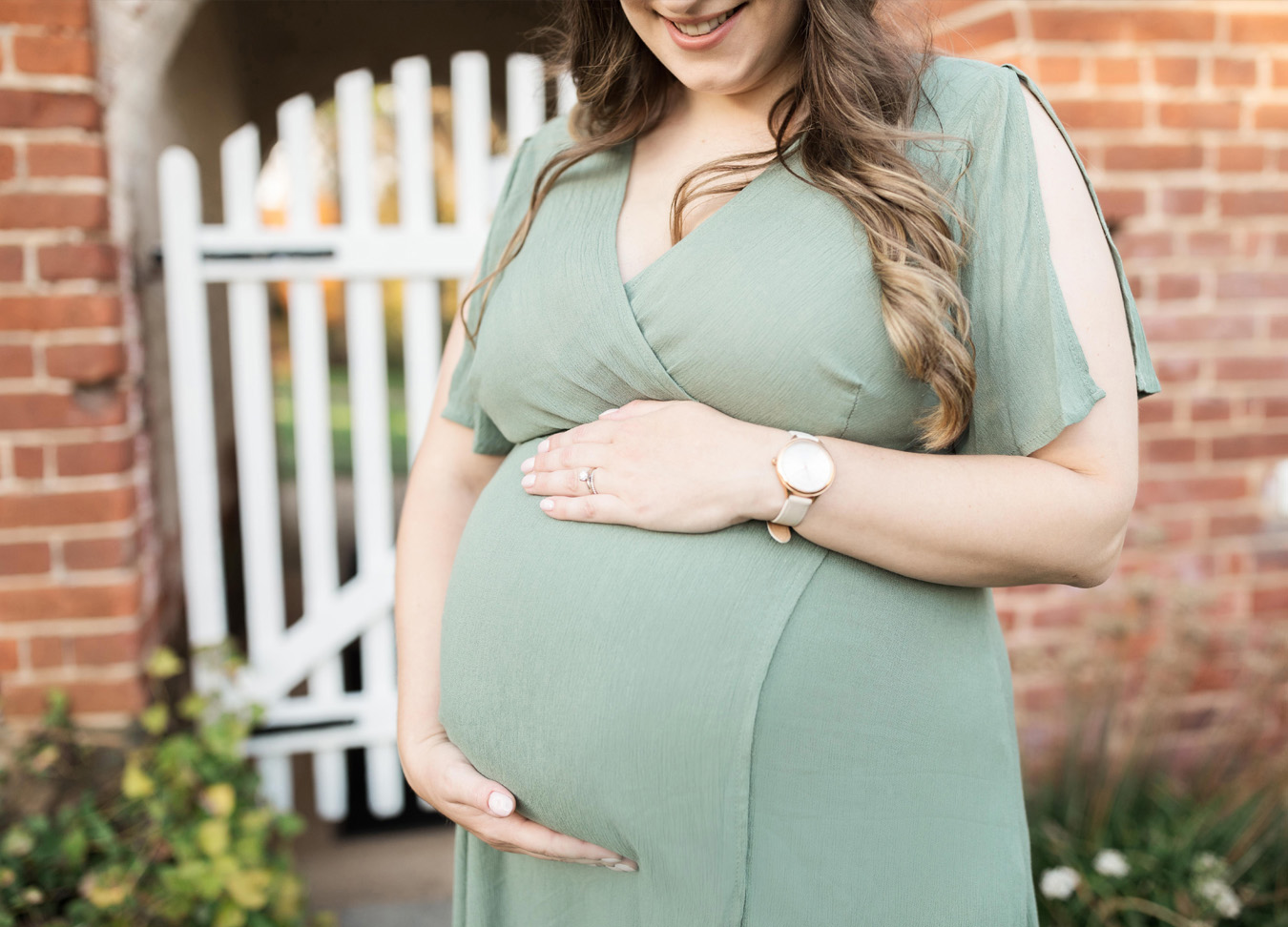 Maternity Clothes in D.C. post featuring a mom smiling and holding her pregnant belly