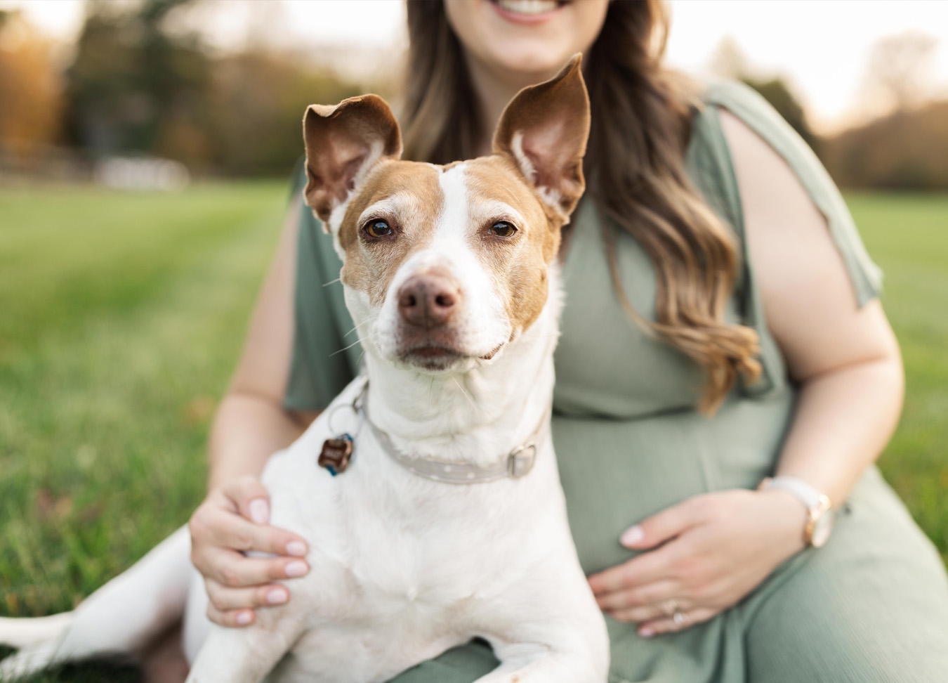 pregnant mom and her dog smile in a picture together