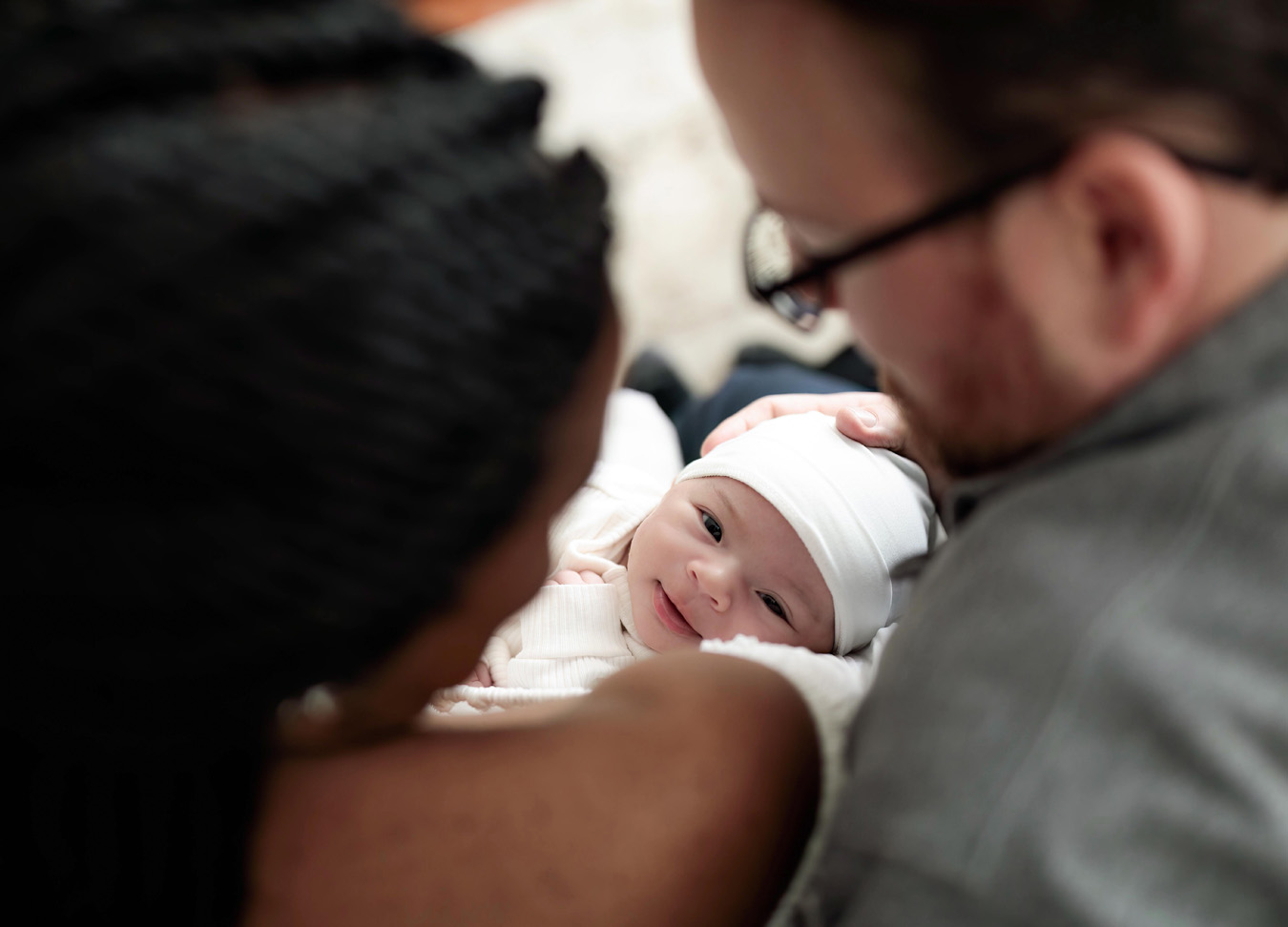 newborn baby looking at her Mom and Dad, captured by a newborn photographer in northern virginia